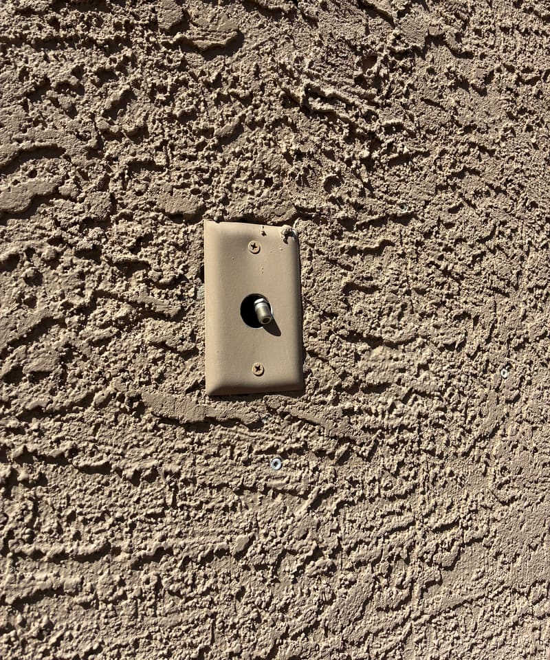 Wall plate mounted on textured stucco, checked for gaps behind it.